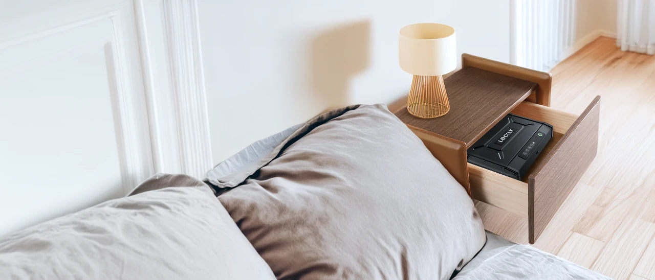 Bedroom with a bed and nightstand featuring a lamp and a smart safe.